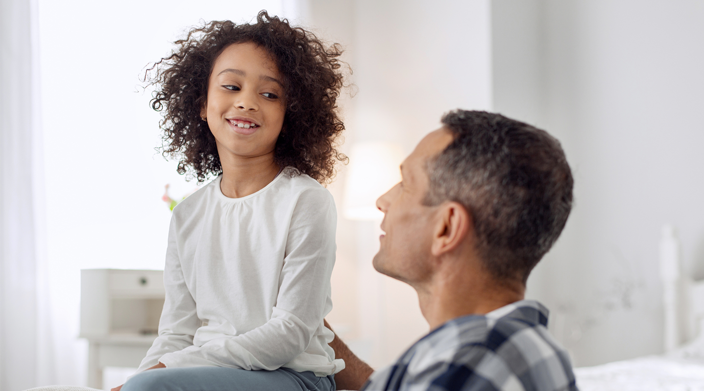 girl talking to dad in bed