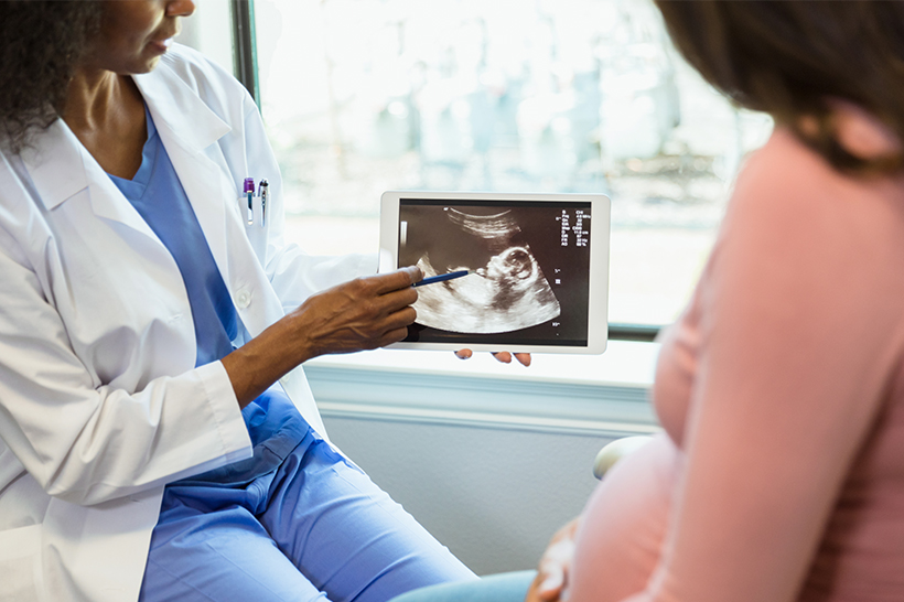 doctor reviewing ultrasound with pregnant woman